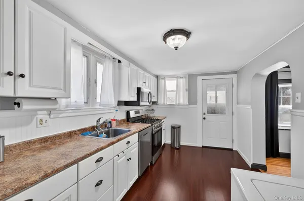 a kitchen with granite countertop white cabinets and white appliances