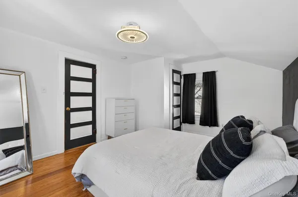 a bedroom with a bed and a flat tv screen on a dresser