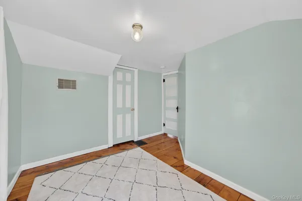 a bedroom with a bed and a lamp on the dresser