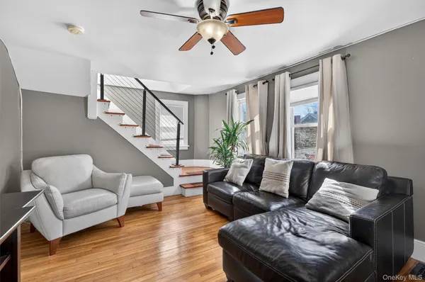 a living room with furniture and a ceiling fan