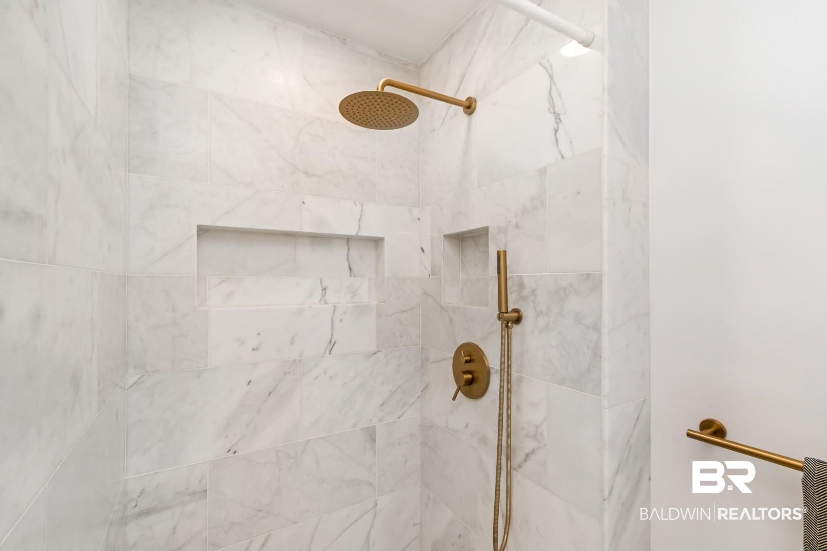4596 Hawthorne Place Mobile, AL 36608 - Photo 21 of 34 Shower enclosure with large format white tile, integrated shower niche, bronze-finish overhead shower, hand shower, and wall-mounted controls