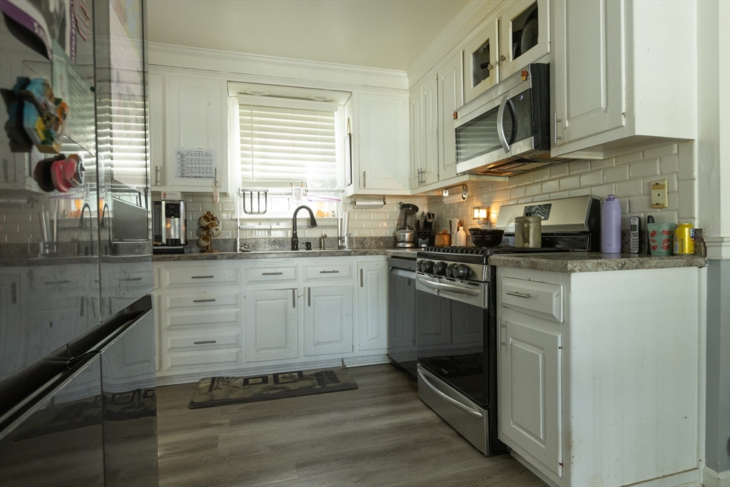 25 Beaconsfield Street Lawrence, MA 01843 - Photo 6 of 36 a kitchen with stainless steel appliances granite countertop a sink and cabinets