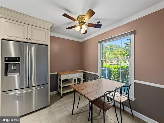 a kitchen with stainless steel appliances a table chairs and a refrigerator