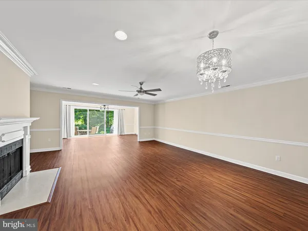 a view of empty room with wooden floor and fireplace