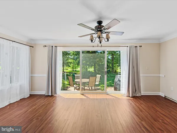 a view of a livingroom with a large window wooden floor and front door