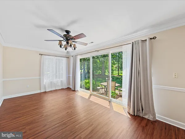 a view of a livingroom with wooden floor and a ceiling fan