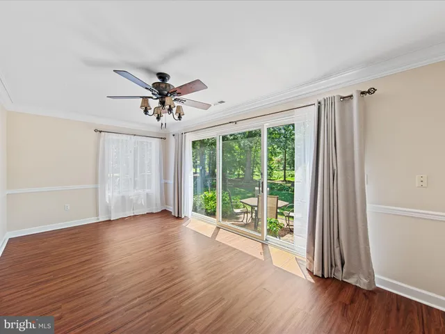 a view of a livingroom with wooden floor and a ceiling fan