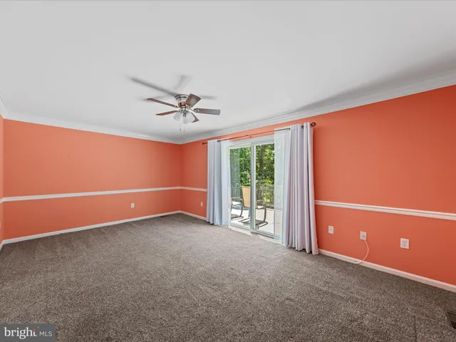 an empty room with a ceiling fan and window