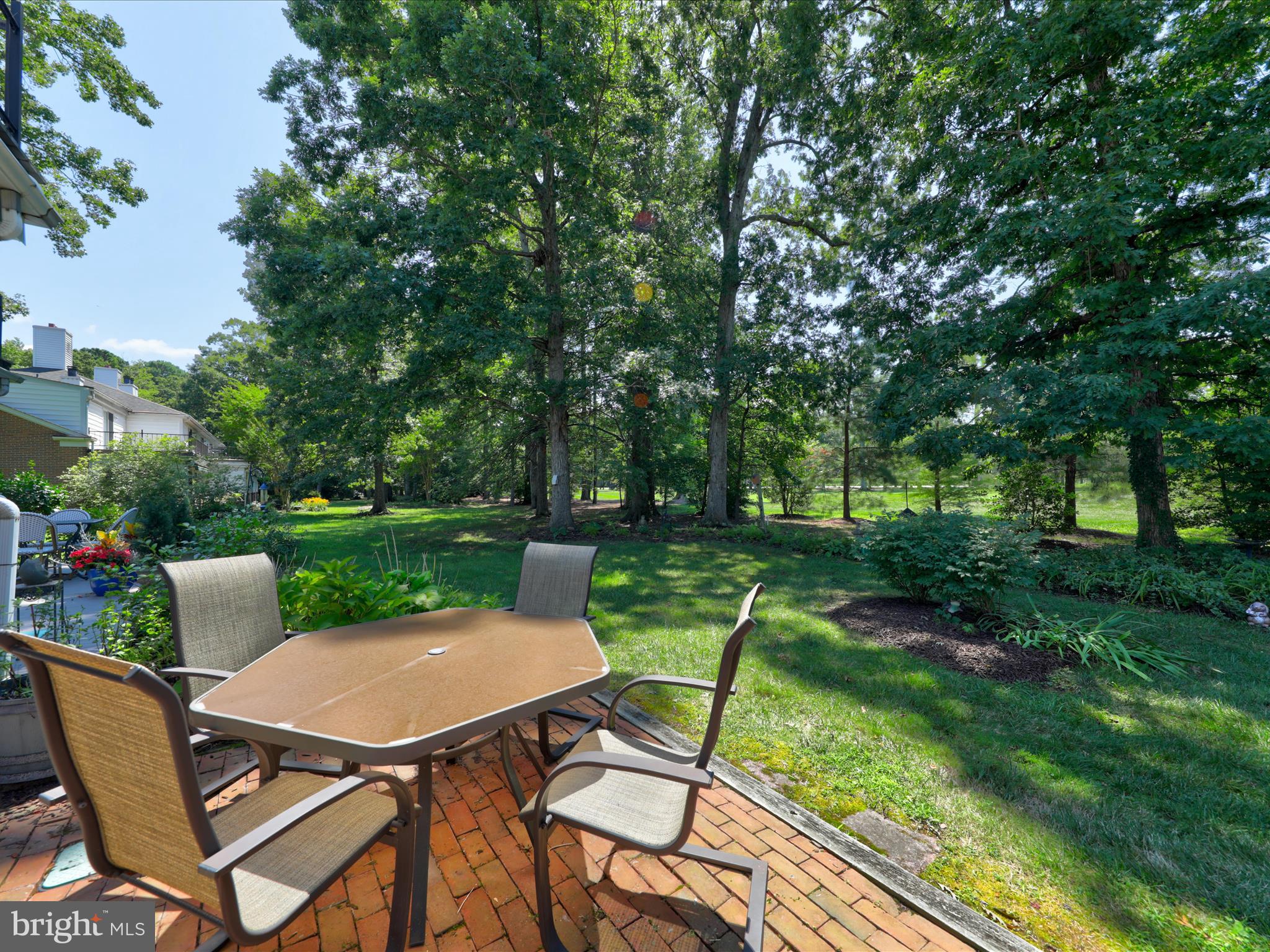 24345 Widgeon Place, Unit 29 St. Michaels, MD 21663 - Photo 34 of 38 a view of a table and chairs in backyard of the house