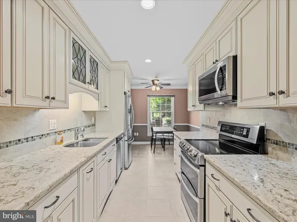 a kitchen with stainless steel appliances granite countertop a sink stove and microwave