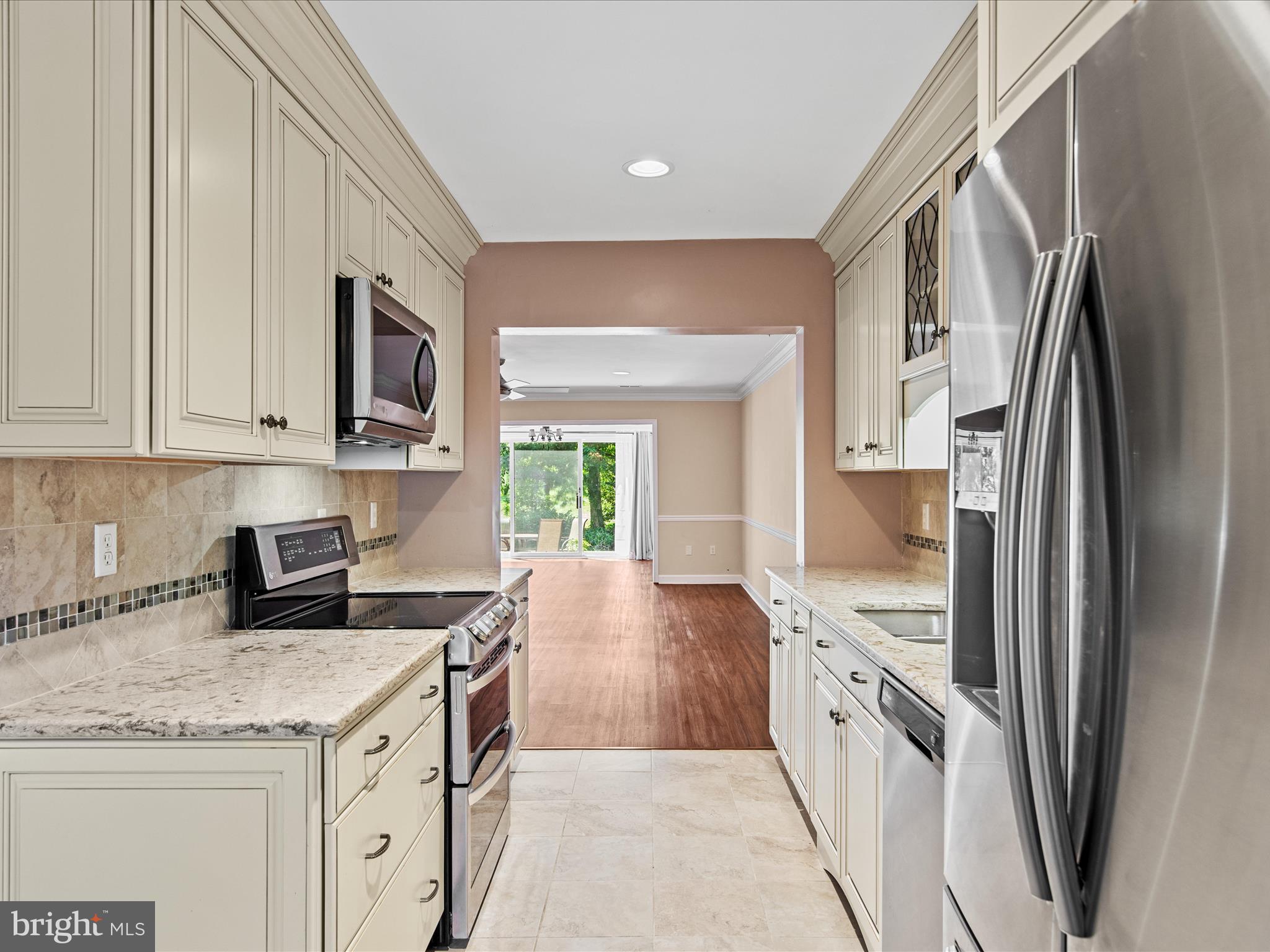 24345 Widgeon Place, Unit 29 St. Michaels, MD 21663 - Photo 10 of 38 a kitchen with stainless steel appliances granite countertop a refrigerator a stove and a sink
