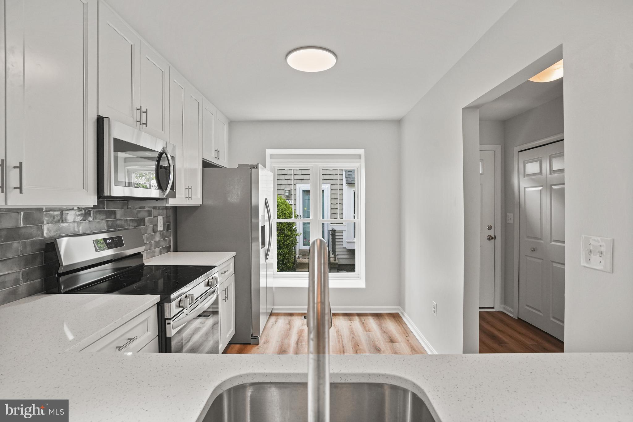 3823 9th Road South Arlington, VA 22204 - Photo 5 of 40 a kitchen with granite countertop a sink and white cabinets