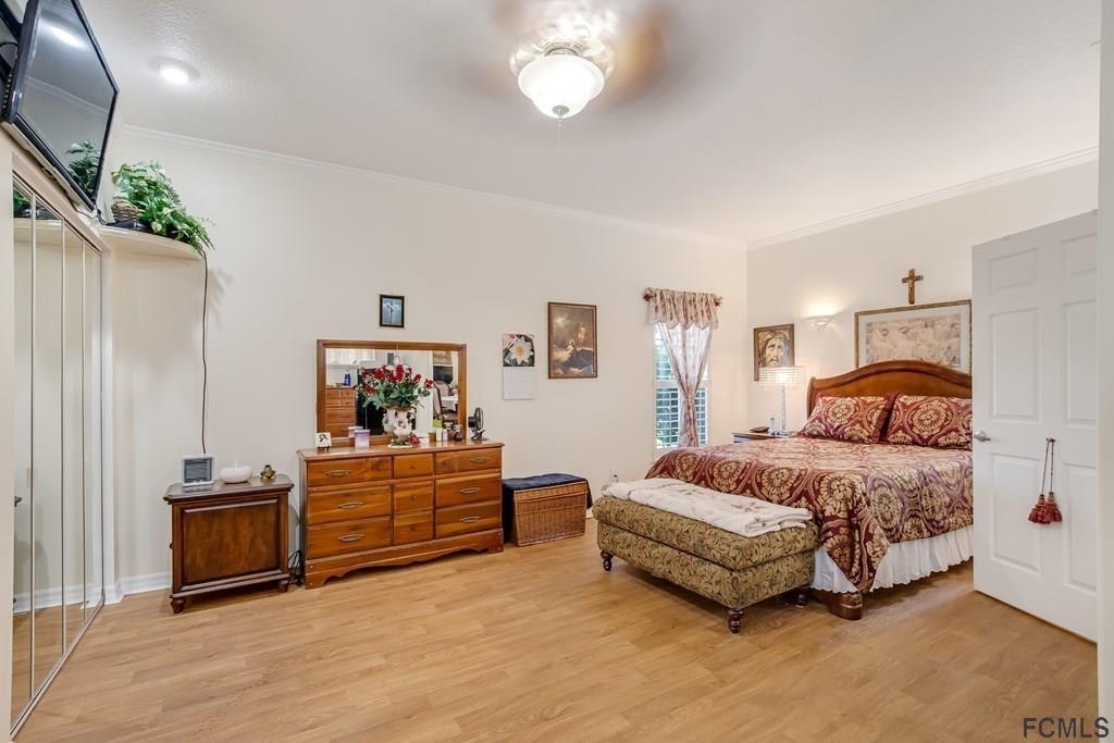 407 Domenico Circle St. Augustine, FL 32086 - Photo 18 of 33 a spacious bedroom with a bed and a chandelier