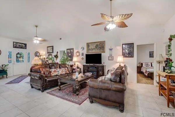 a living room with furniture a flat screen tv and a window