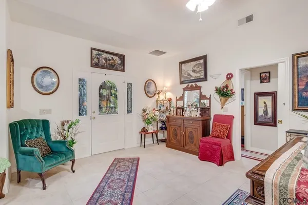 a living room with furniture a rug and wall paintings