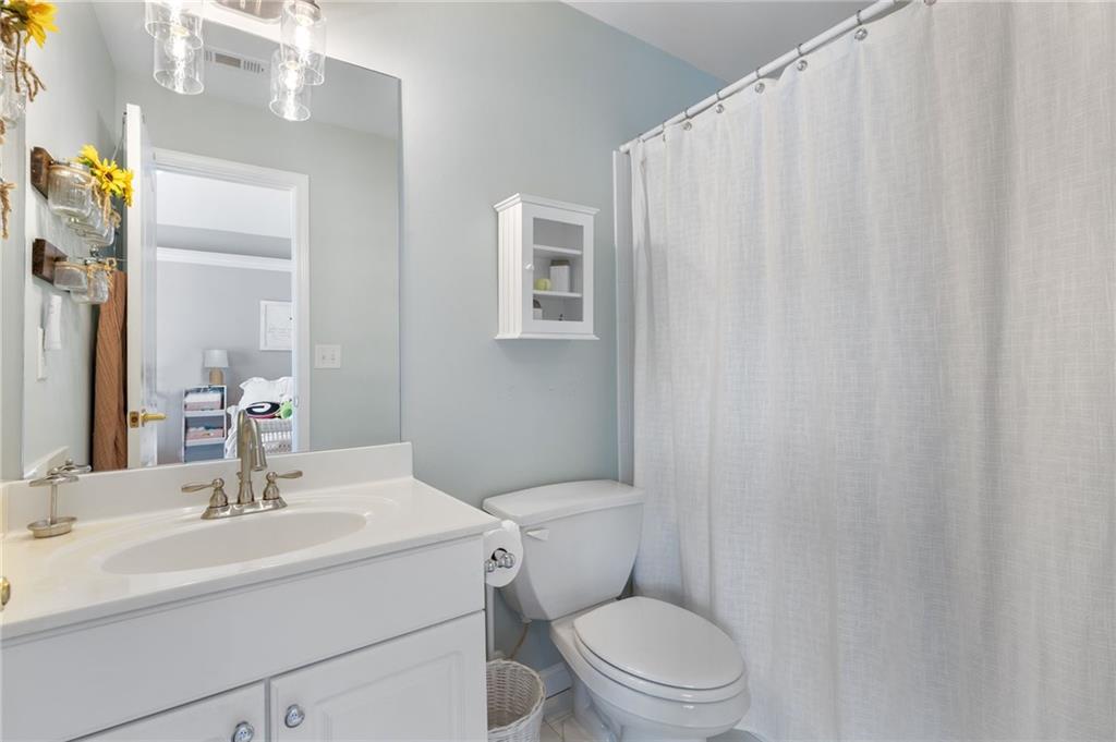 2964 Mill Grove Terrace Dacula, GA 30019 - Photo 36 of 86 a bathroom with a sink a toilet and shower curtain