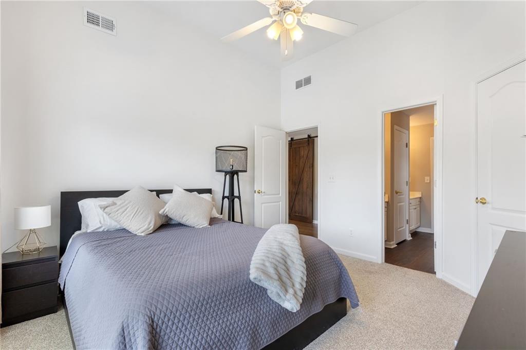2964 Mill Grove Terrace Dacula, GA 30019 - Photo 37 of 86 a bedroom with a large bed and a chandelier