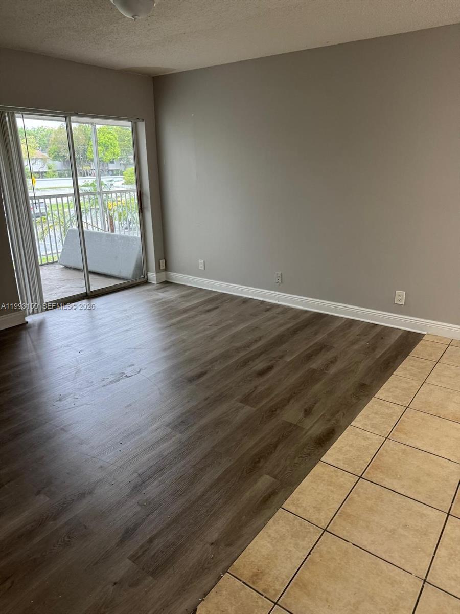 5780 Rock Island Road, Unit 362 Tamarac, FL 33319 - Photo 2 of 10 an empty room with wooden floor and windows