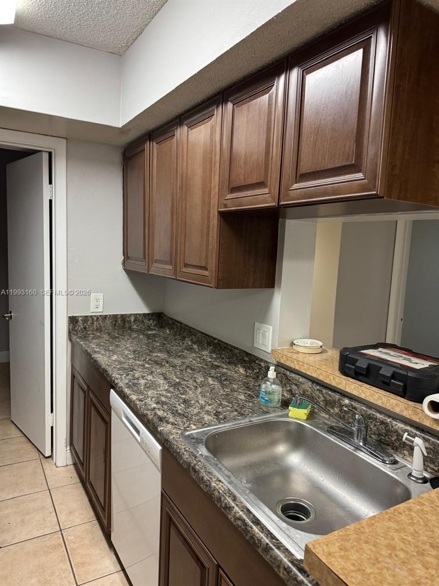 5780 Rock Island Road, Unit 362 Tamarac, FL 33319 - Photo 3 of 10 a kitchen with granite countertop a sink a stove and cabinets