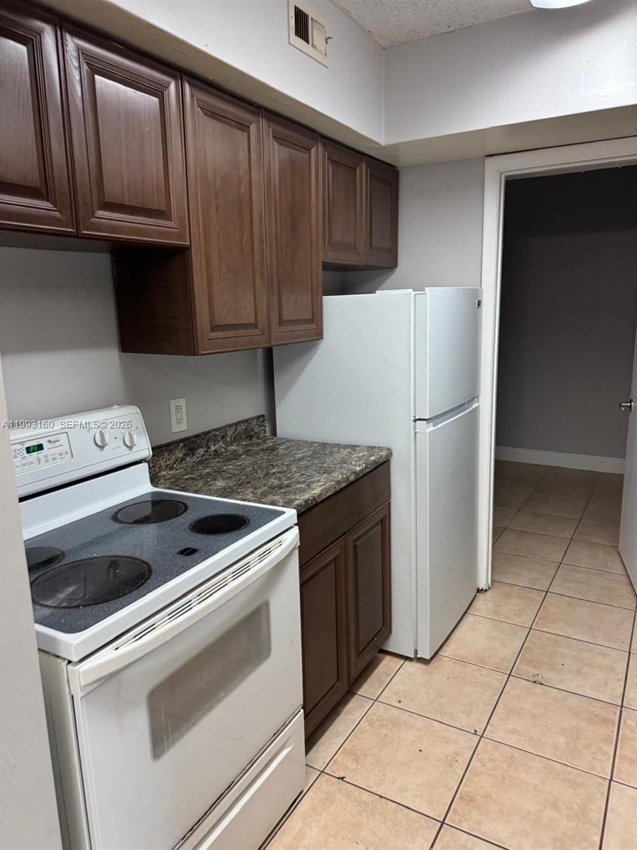 5780 Rock Island Road, Unit 362 Tamarac, FL 33319 - Photo 4 of 10 a kitchen with granite countertop cabinets and refrigerator