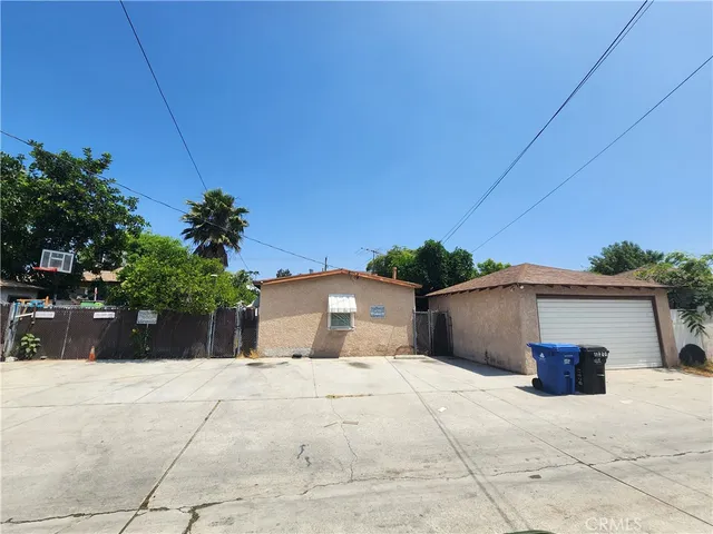 a view of a house with a yard and potted plants