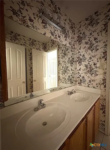 a spacious bathroom with a tub sink and mirror
