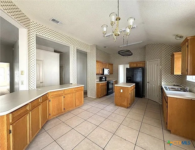 a kitchen that has a lot of cabinets in it and stainless steel appliances