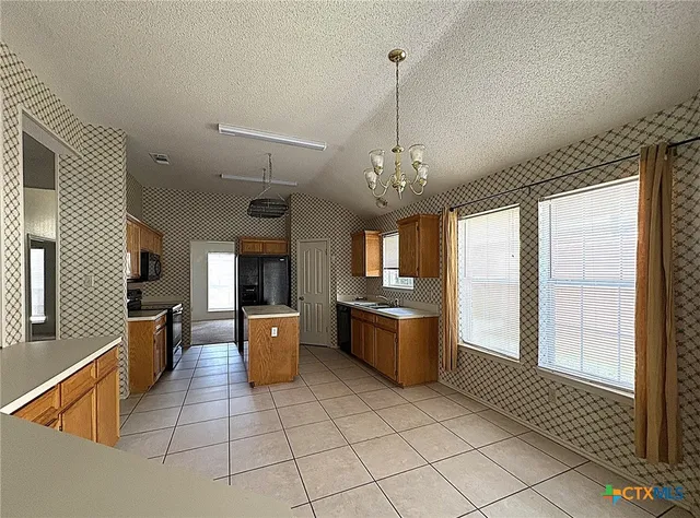 an empty room with a fireplace and a ceiling fan