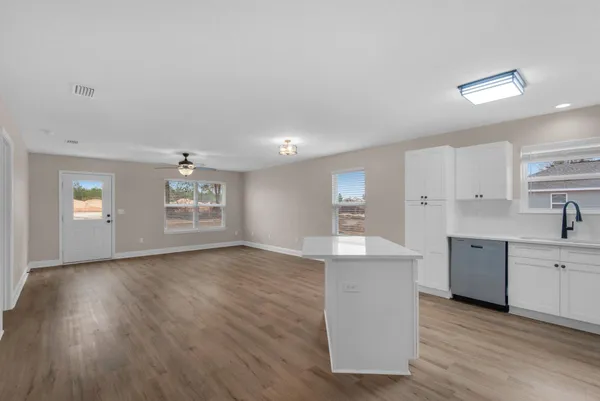 a view of a kitchen with wooden floor and windows