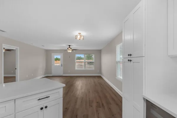 a view of hallway with window and hardwood floor