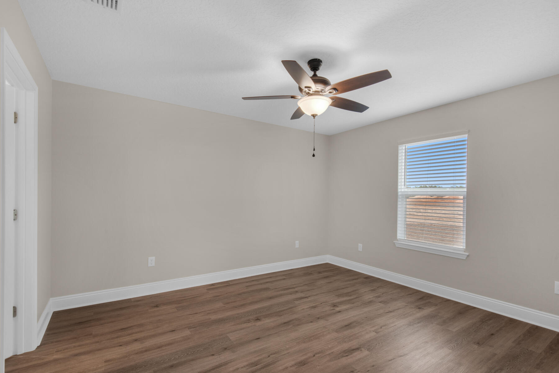 5438 Bayleaf Drive Crestview, FL 32539 - Photo 17 of 35 a view of an empty room with wooden floor and a window
