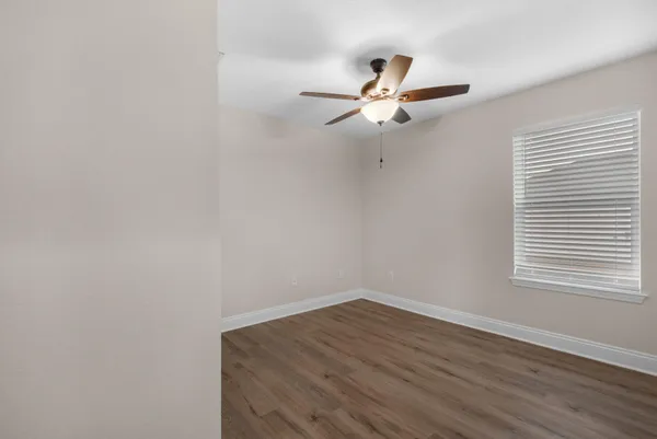 a view of a room with wooden floor and fan
