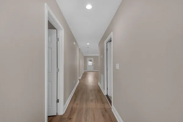 a view of a hallway with wooden floor