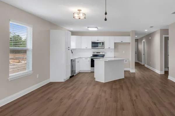 a view of kitchen with stainless steel appliances refrigerator stove microwave and cabinets