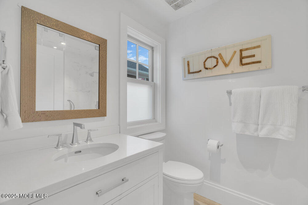 985 North Ocean Avenue Mantoloking, NJ 08738 - Photo 119 of 163 a bathroom with a sink mirror vanity and toilet