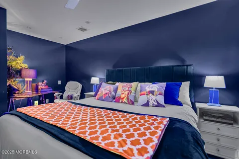 a bedroom with a large bed and a chandelier
