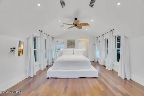 a bedroom with a large bed and a flat tv screen