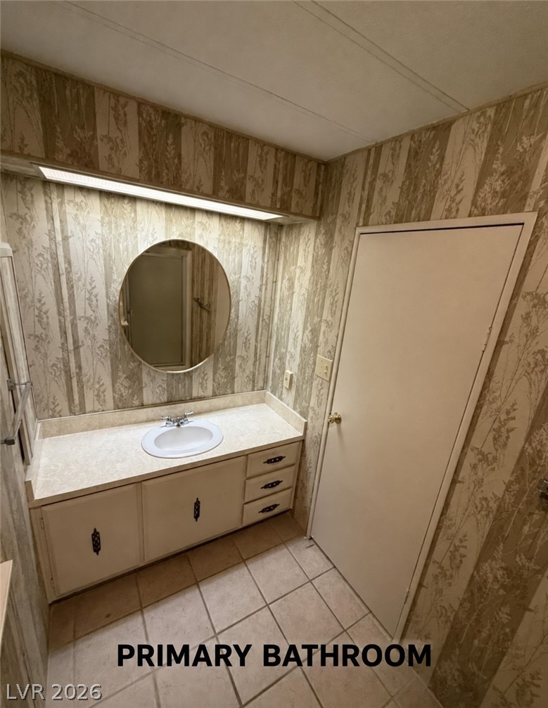 4556 Royal Ridge Way Las Vegas, NV 89103 - Photo 15 of 49 A classic vanity setup pairs with tiled flooring in this primary bathroom.