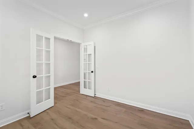 an empty room with wooden floor and entrance