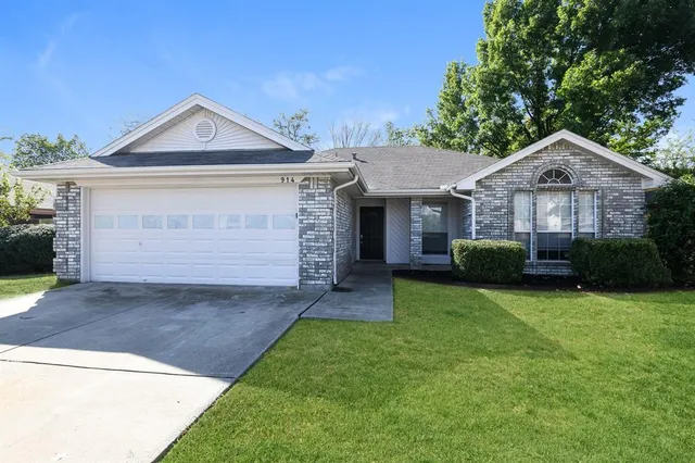 a front view of a house with a garden and yard