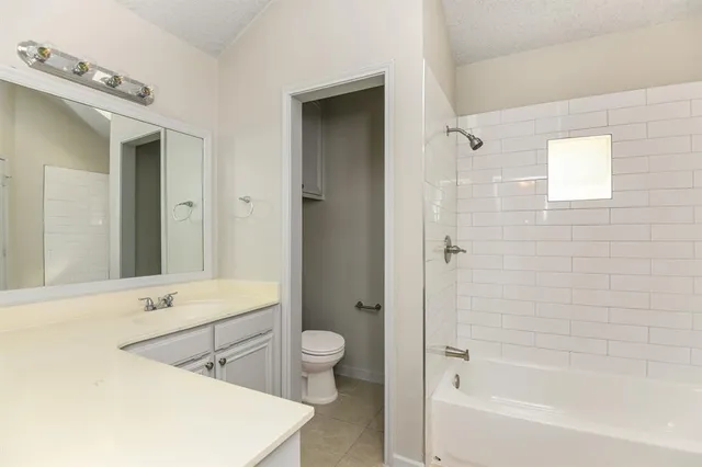 a bathroom with a bathtub sink vanity mirror and toilet