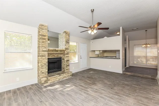 a view of a kitchen with a stove cabinets wooden floor and a fireplace