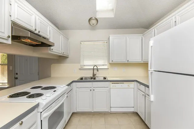 a kitchen with a white cabinets sink and white stainless steel appliances
