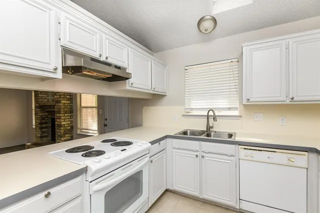 a kitchen with cabinets appliances a sink and a window