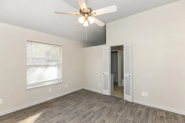 a view of an empty room with window and wooden floor