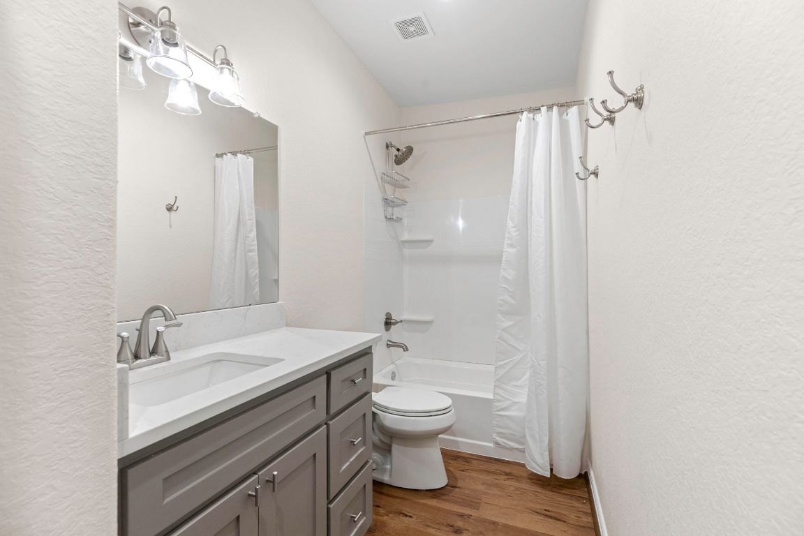 1303 Aransas Street Lockhart, TX 78644 - Photo 9 of 16 a bathroom with a sink a toilet and shower