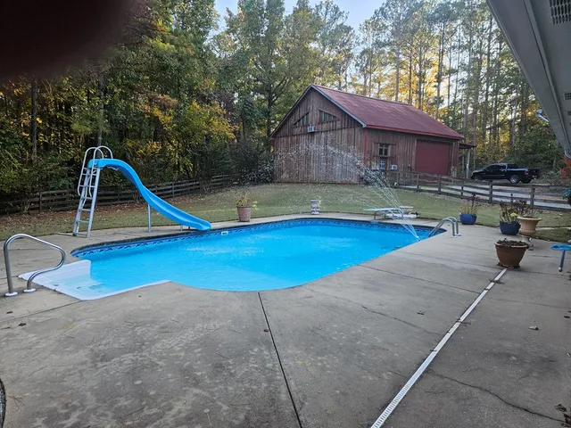 a swimming pool with outdoor seating and yard
