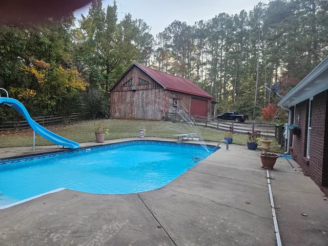 a view of a backyard with swimming pool