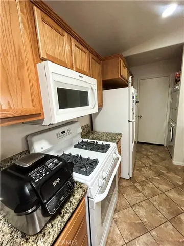 a kitchen with stainless steel appliances kitchen island granite countertop a stove and a sink