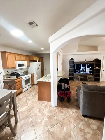 a kitchen with kitchen island granite countertop wooden cabinets and a counter top space